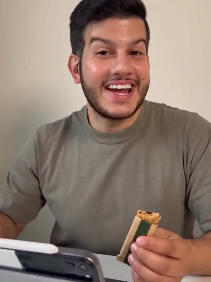 Raed at his desk holding a snack bar
