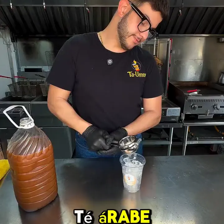 Raed pouring tea in a restaurant kitchen