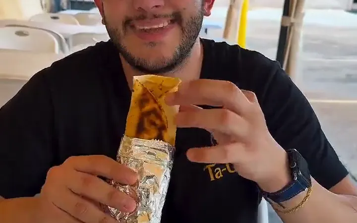 Raed holding a shawarma wrap